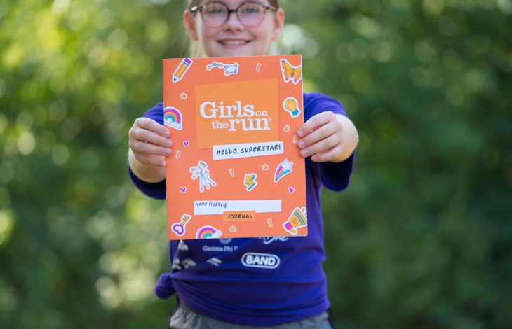 GOTR Participant smiles while holding a Hello, Superstar! journal out